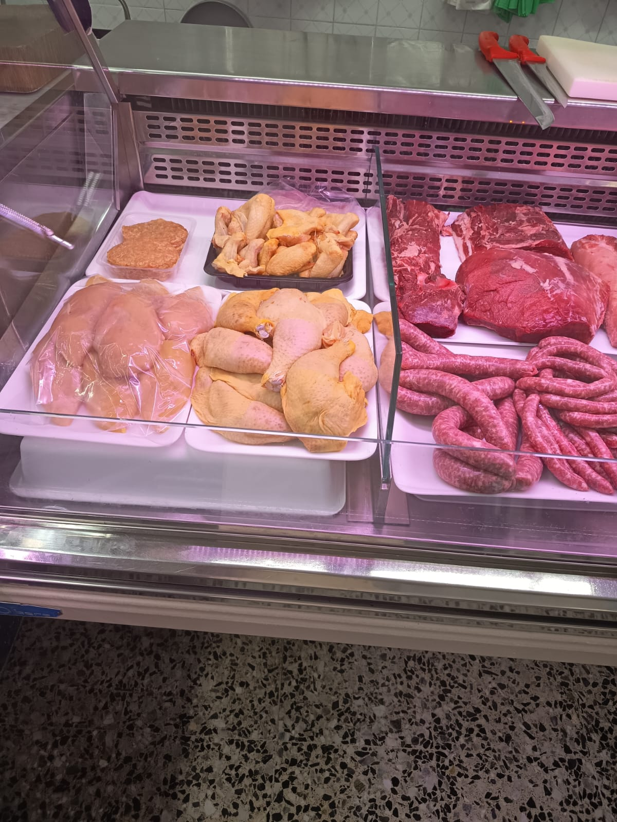 Carne de pollo, cerdo y embutidos presentados en bandeja en vitrina